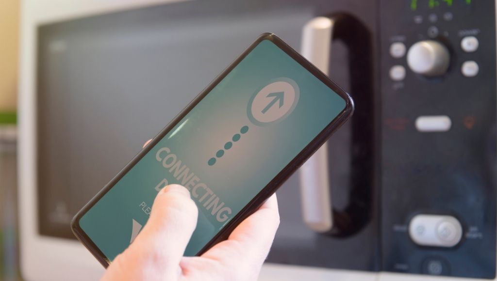 A beautiful lady is heating food in a smart oven