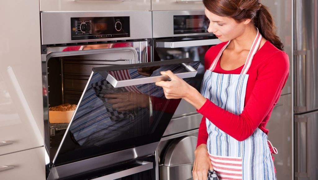 A beautiful lady is heating food in a smart oven